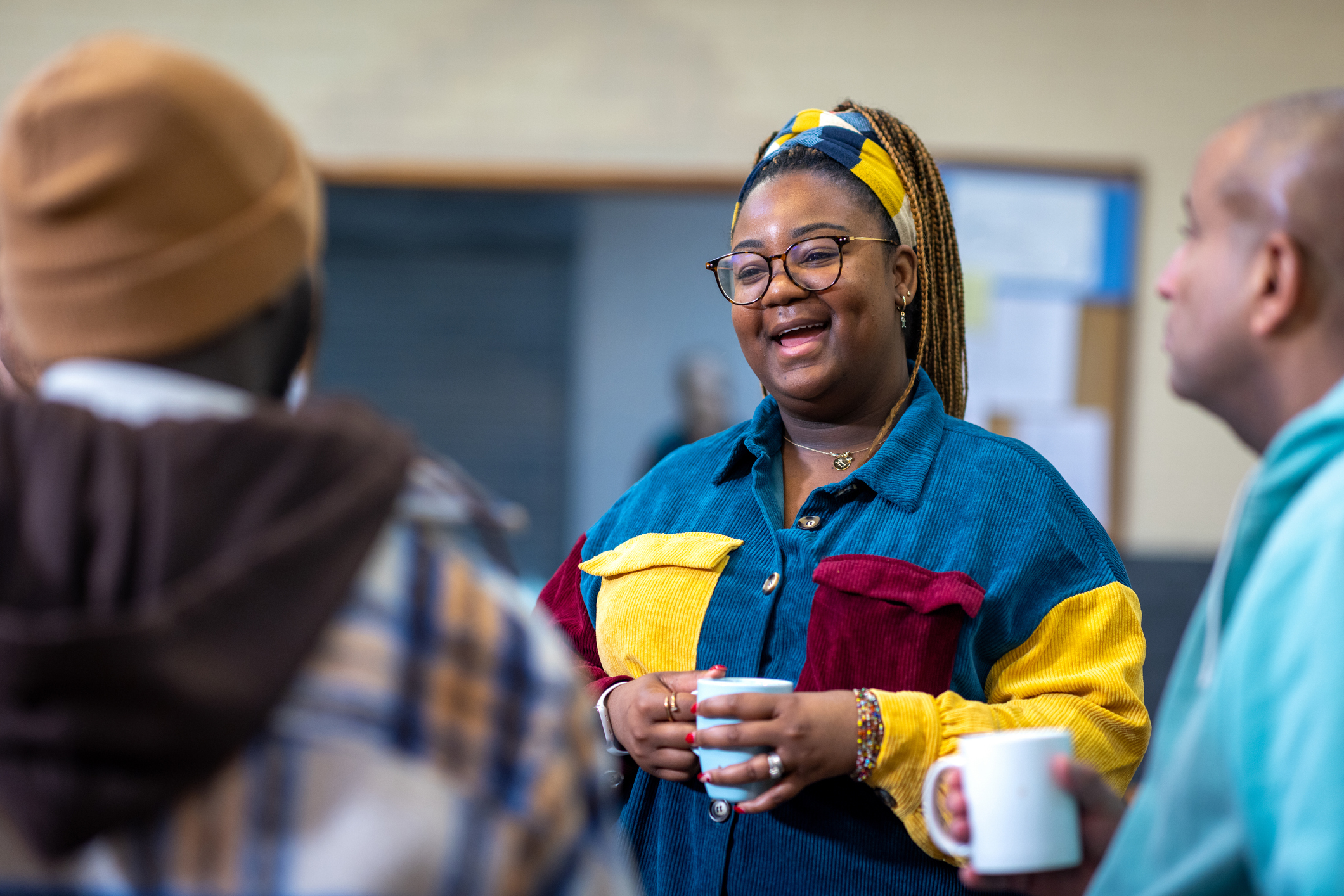 Person smiling holding cup